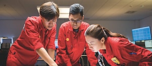 Three employees reviewing plans