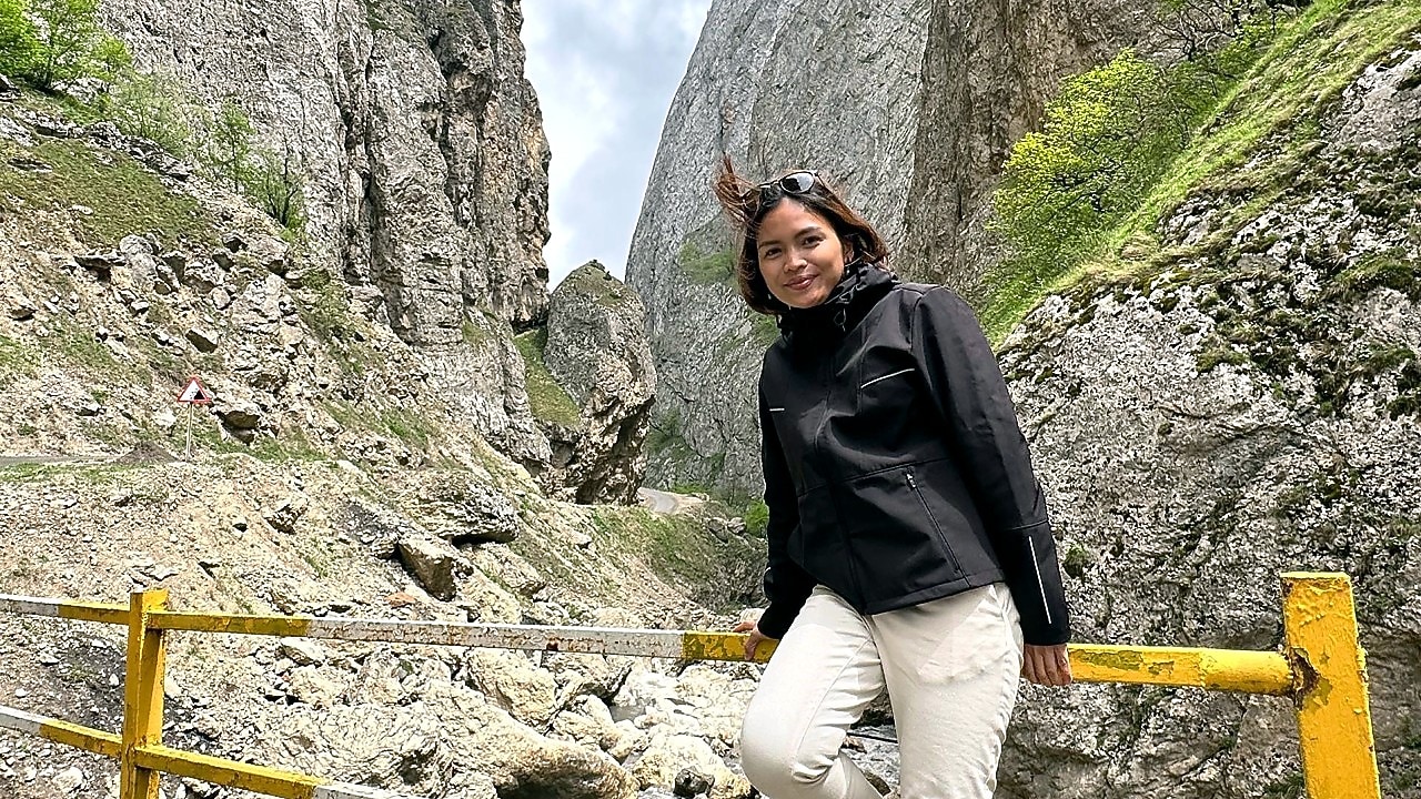 An engineer posing in front of a mountain during her vacation