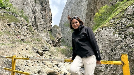 An engineer posing in front of a mountain during her vacation