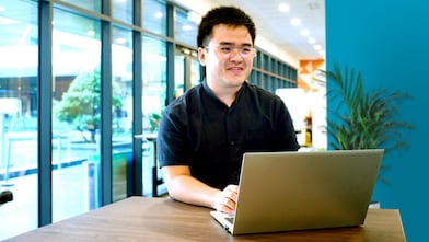 An employee at office looking into his laptop screen.