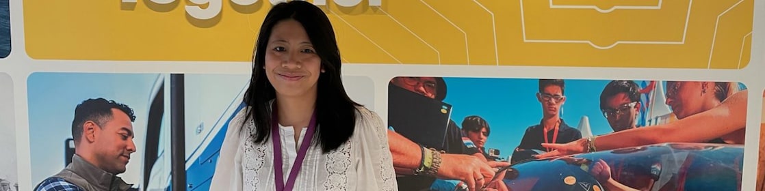 Person standing before a Shell display with the message “We Power Progress Together” and photos of employees and teamwork