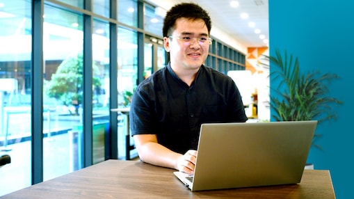 Heng working on his laptop at office.