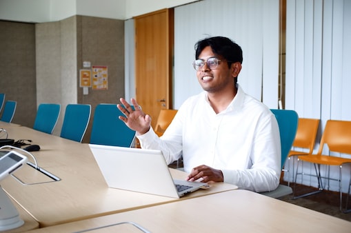 Hakim's talking to someone while he is at his laptop simultaneously working.