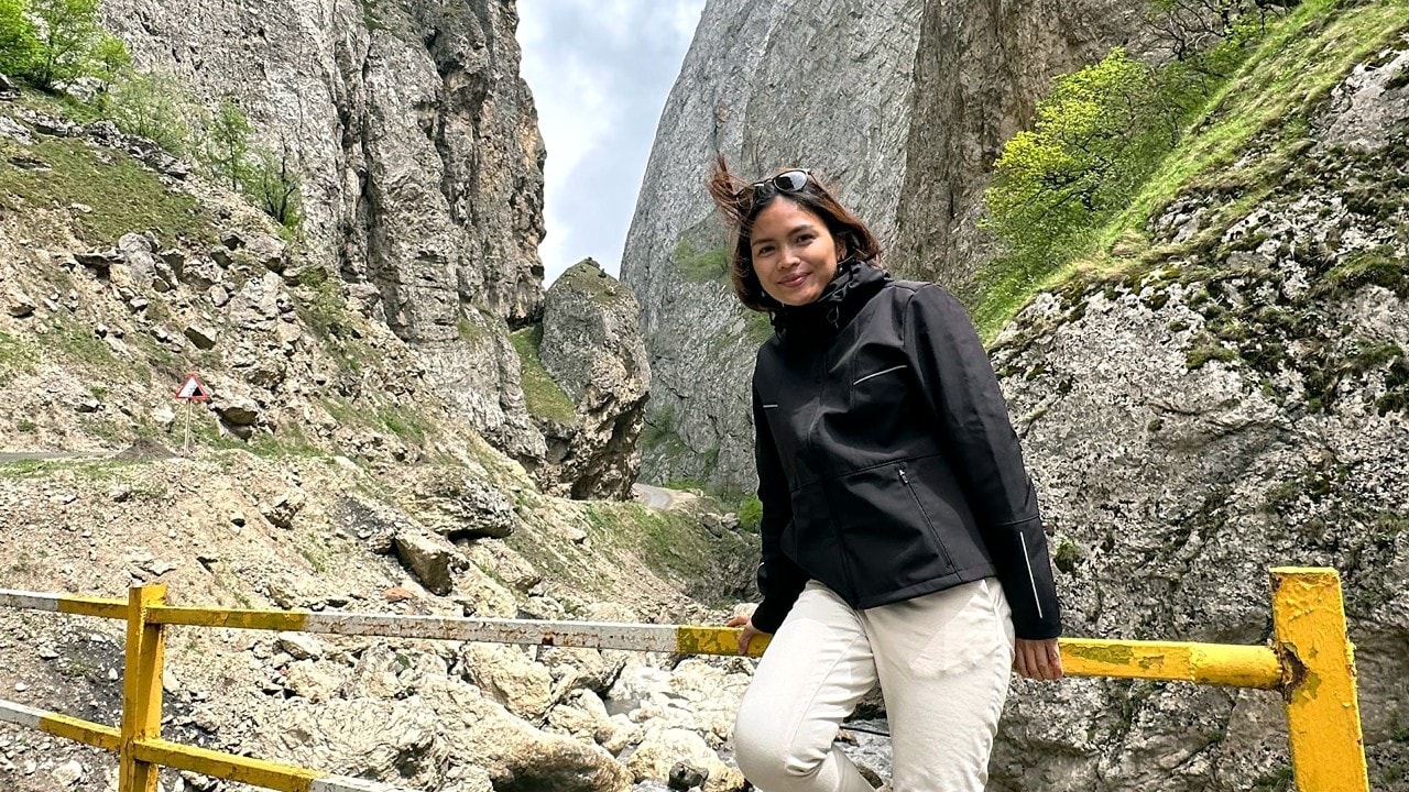 An engineer posing in front of a mountain during her vacation