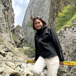 An engineer posing in front of a mountain during her vacation