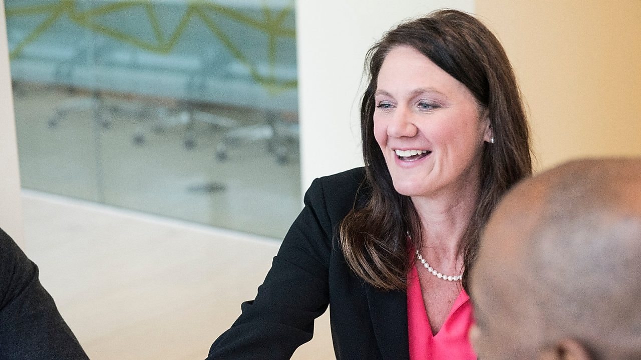 A female experienced professional at Shell smiling during a meeting.