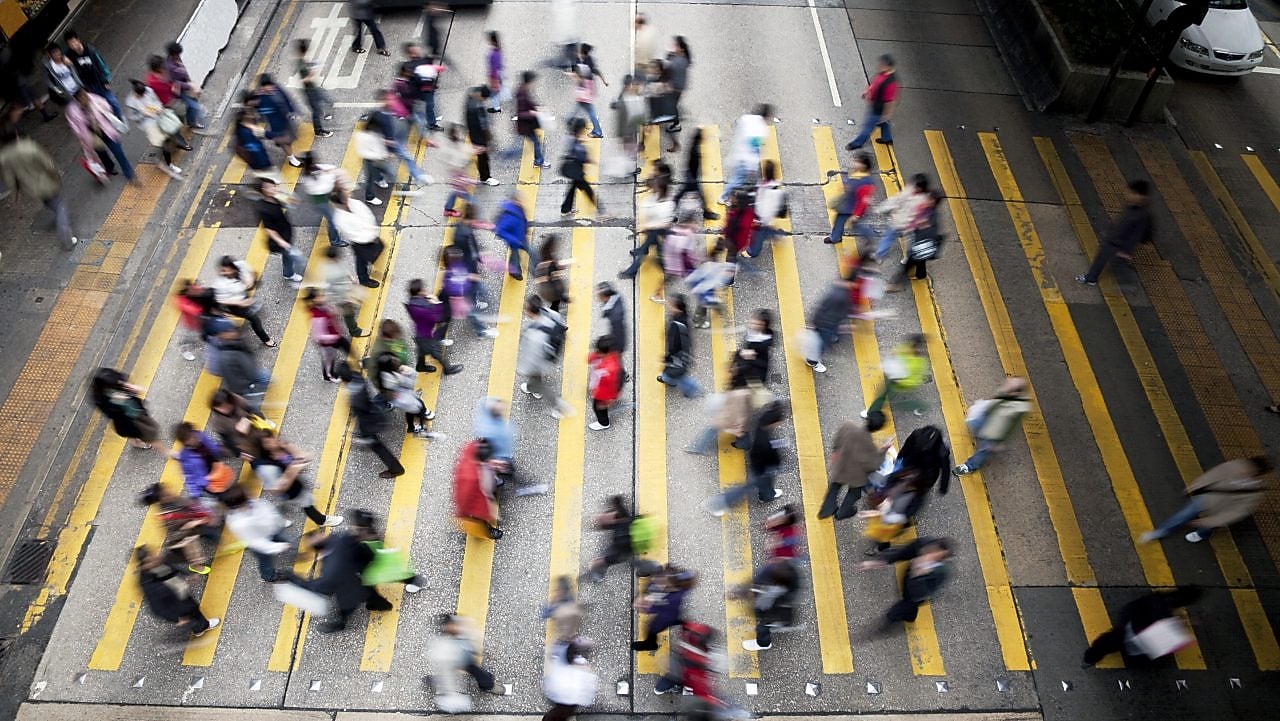 People cross a busy street in Hong Kong