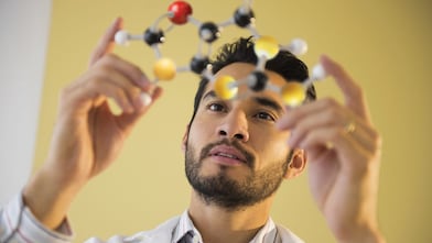 Young man examining molecular model
