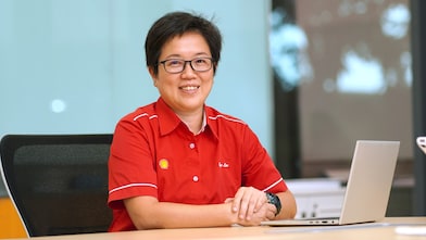 Toh Sze smiling while seated with her laptop in front of her.
