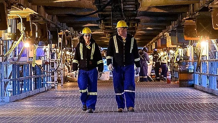 A lady and a man walking in a plant