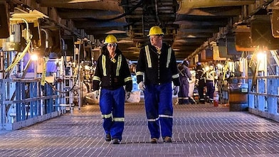 A lady and a man walking in a plant
