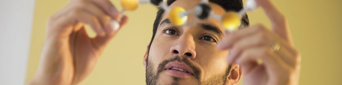 Young man examining molecular model