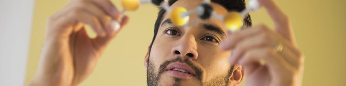 Young man examining molecular model