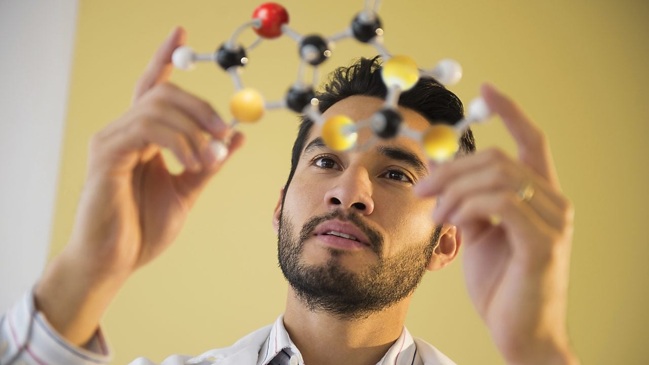 Young man examining molecular model