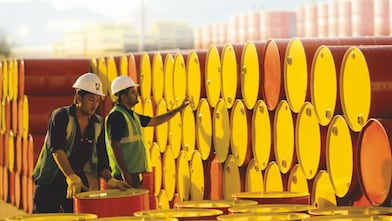 two employees transporting Shell barrels