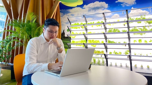 An employee at office looking into his laptop screen.