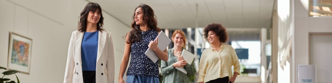 four female employees walking across office space
