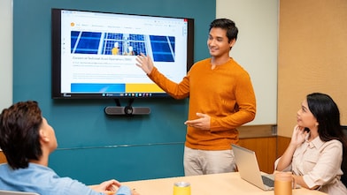 a group of three employees in a discussion in a meeting room