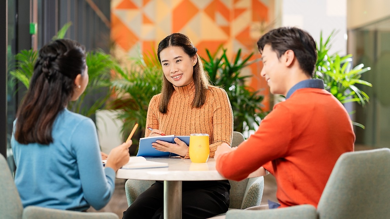 three employees seated at a table