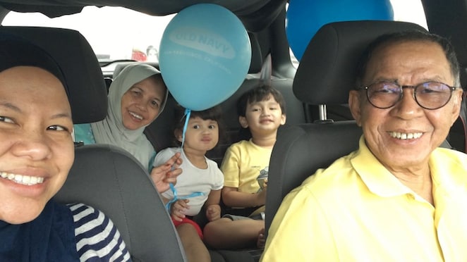 Maria with her family posing for a picture in car