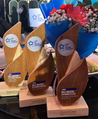 3 trophies for the category where Shell was awarded as champion displayed on a glass table with a bouquet of flower