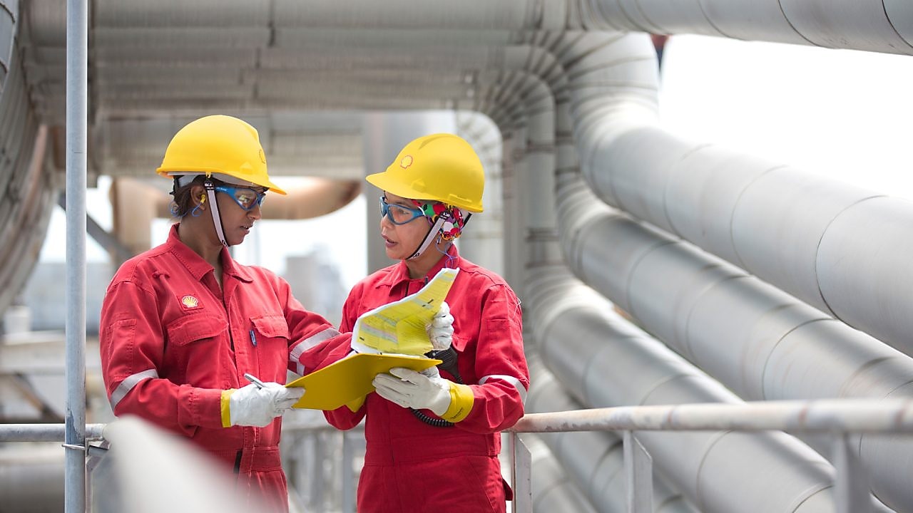 Employees on site discussing work and referring to clipboard