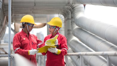 Employees on site discussing work and referring to clipboard