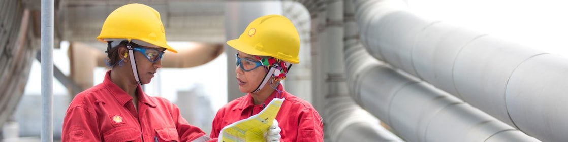 Employees on site discussing work and referring to clipboard