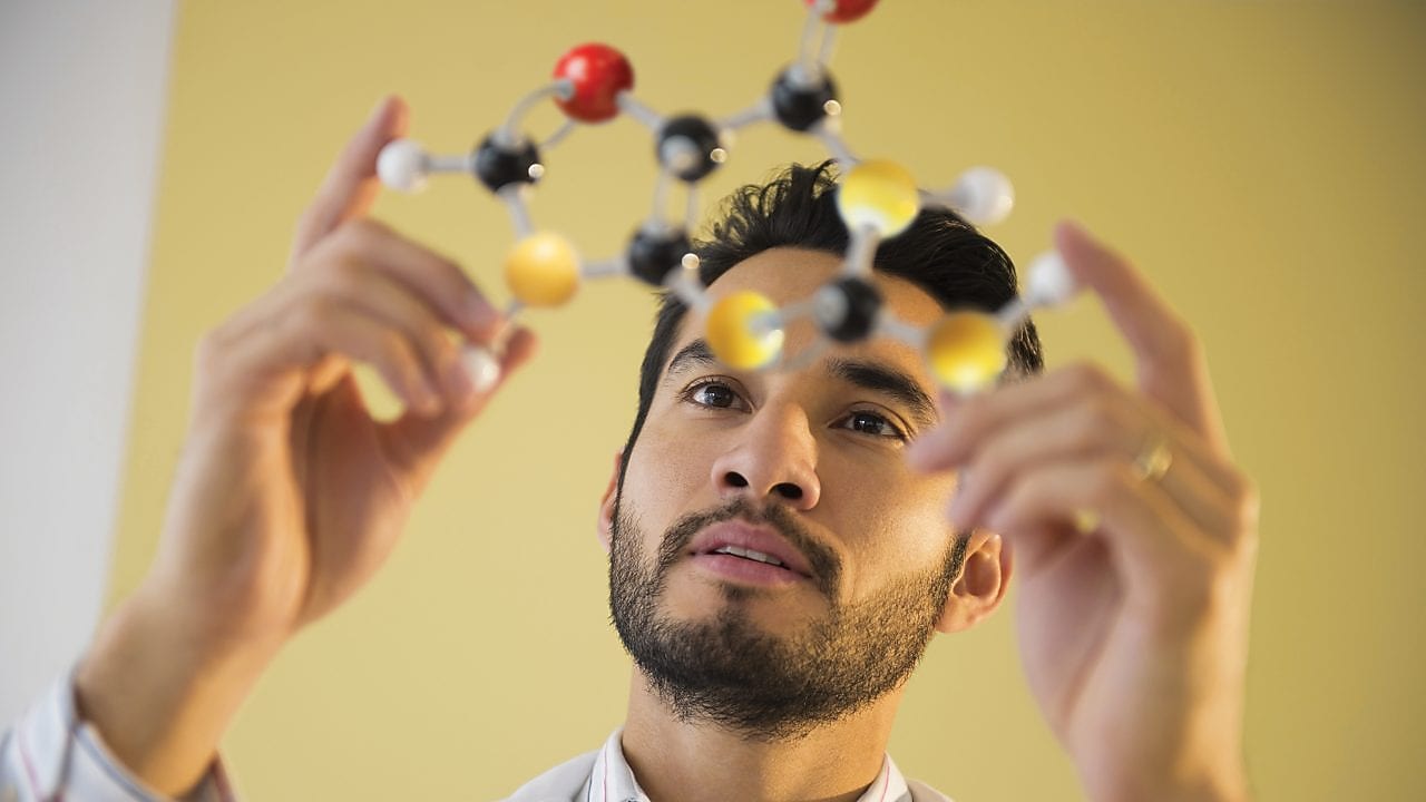 Young man examining molecular model