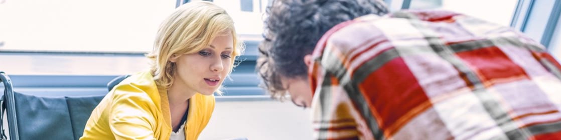 Woman in a wheelchair talking to a man