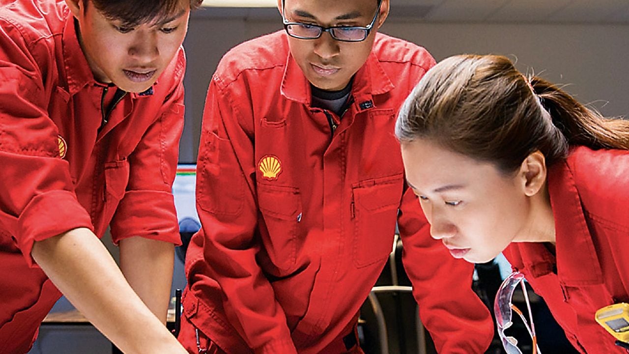 Three people looking at plans