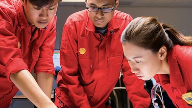 Three people looking at plans
