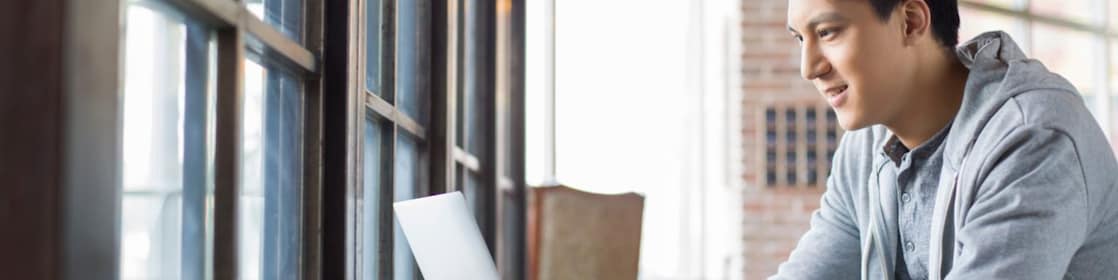 Young man using laptop in cafe
