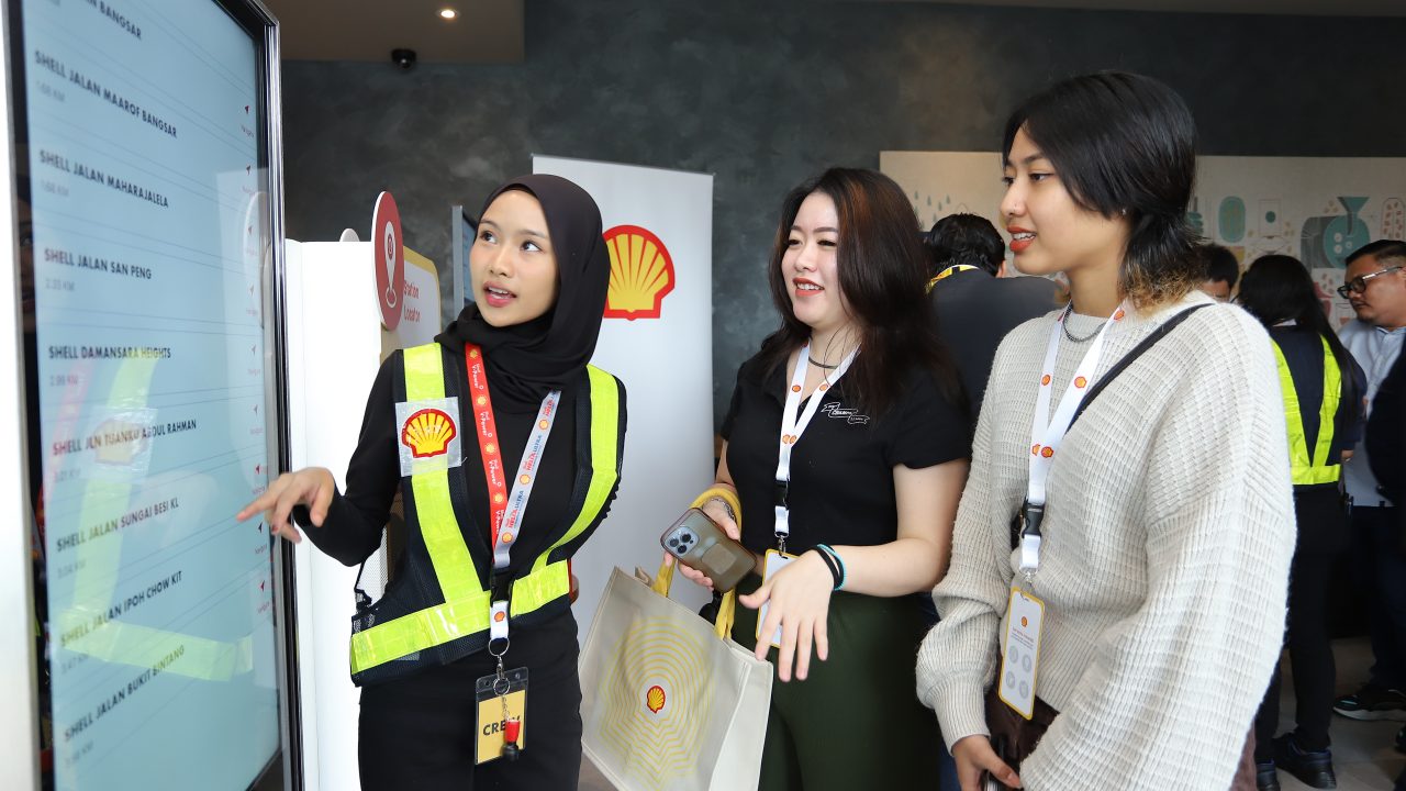 A group of women standing in front of a screen to learn more about Shell App