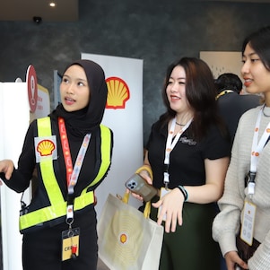 A group of women standing in front of a screen to learn more about Shell App