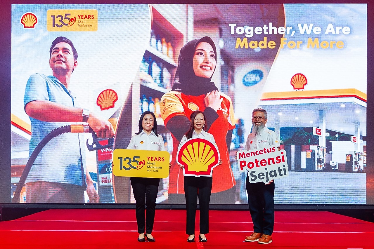 Shell Malaysia team members stand on stage holding anniversary and brand placards, set against a large backdrop celebrating 135 years and the “Together, We Are Made for More” message.