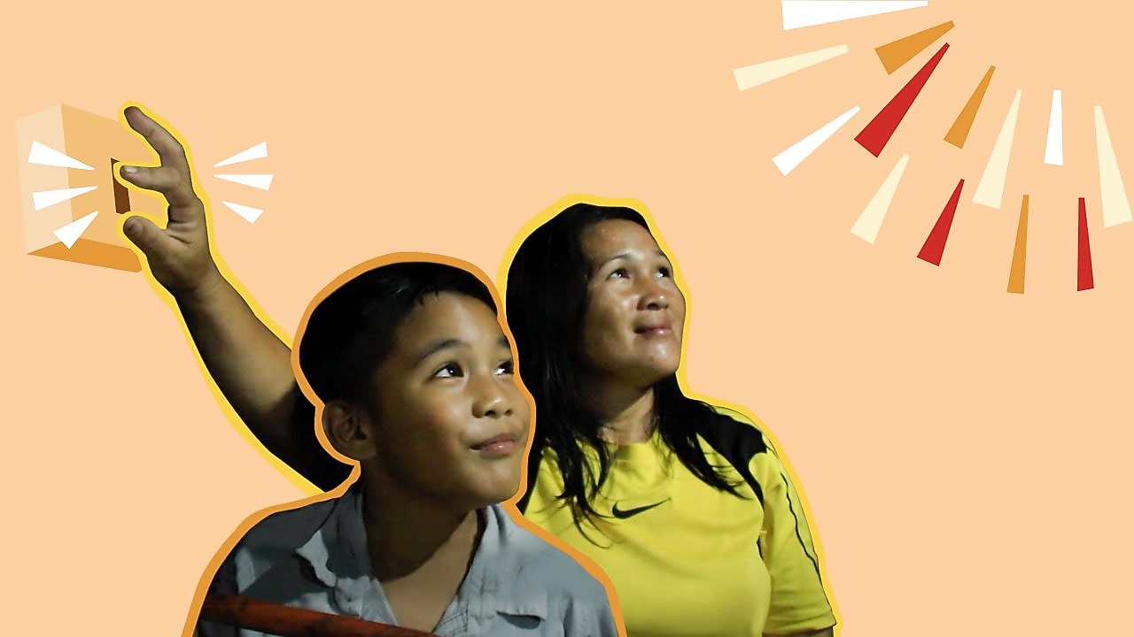 mom and son happily looking at light bulb