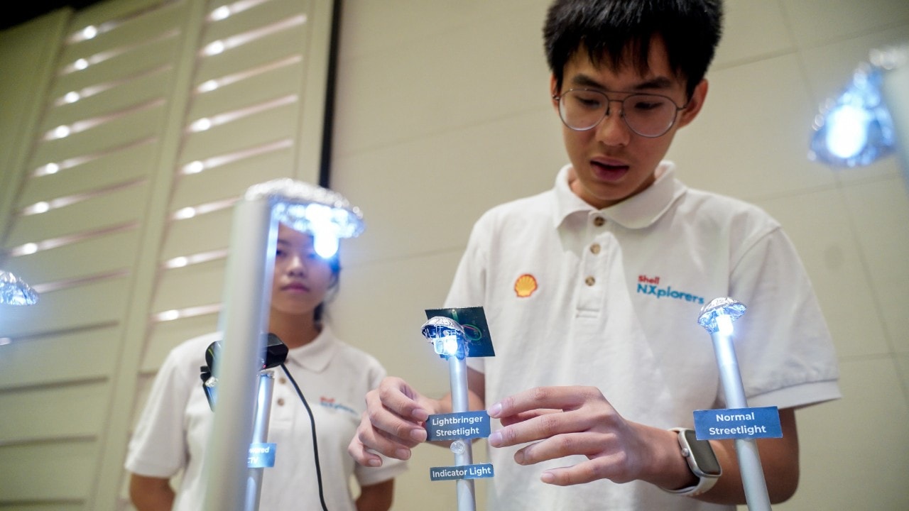 Team The 3 Mechanics preparing their prototype, The Lightbringer, for presentation.