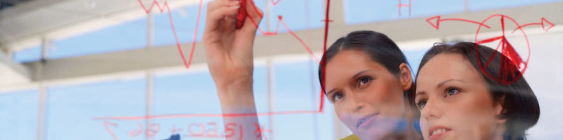 Businesswoman drawing graphs on glass