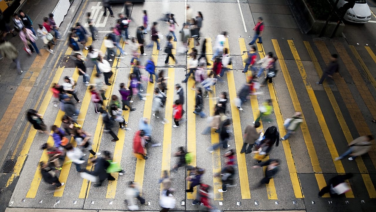 People cross a busy street in Hong Kong