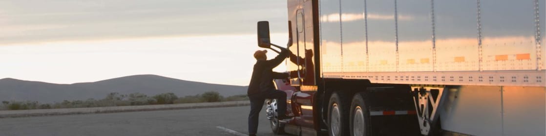 Truck driver climbing into cabin