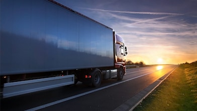 Truck driving into sunset