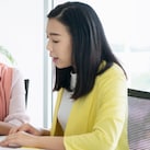 Female inspector discussing with engineer in car factory. Multi-ethnic male and female professionals are standing at car production line. They are in automotive industry.