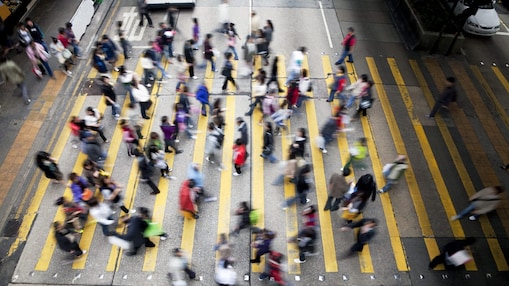 People cross a busy street in Hong Kong