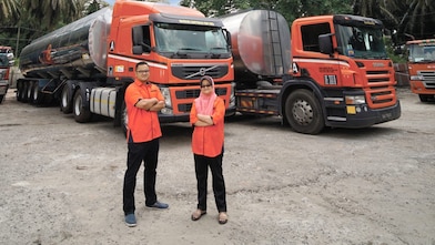 Men and women standing near truck