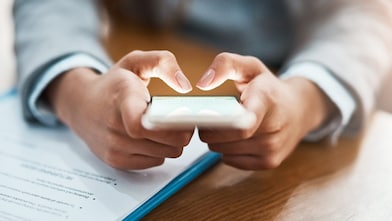 Two hands shown using a mobile device to send an email