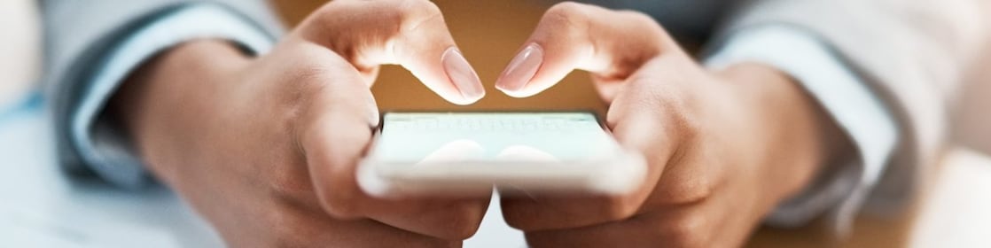 Two hands shown using a mobile device to send an email