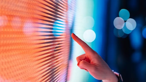Close-up of female hand touching illuminated digital display