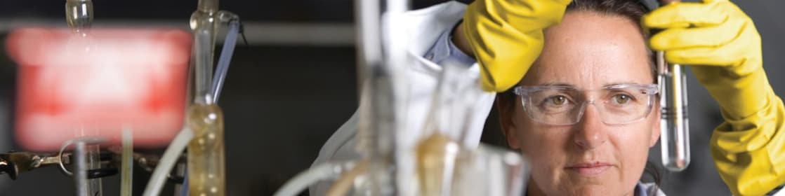 lady in safety goggles conducting a lab experiment