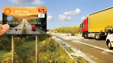 A truck and van on the road with the Shell Card held up in the foreground
